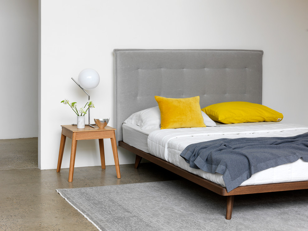Foto di una camera da letto contemporanea con pareti bianche e pavimento in cemento