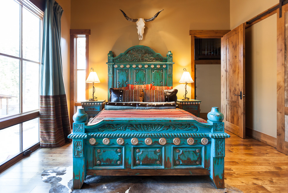 Пример оригинального дизайна: спальня в стиле фьюжн с бежевыми стенами, темным паркетным полом и синими шторами