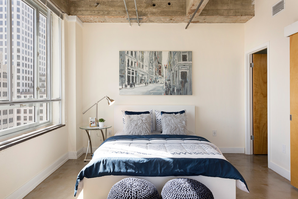 Cette image montre une petite chambre urbaine avec un mur beige, sol en béton ciré et aucune cheminée.