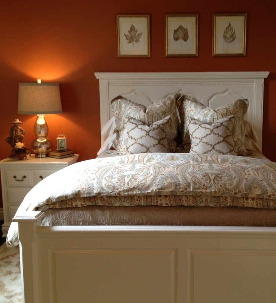 オクラホマシティにある中くらいなトラディショナルスタイルのおしゃれな客用寝室 (オレンジの壁、無垢フローリング、茶色い床) のレイアウト
