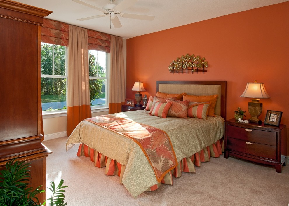 Esempio di una camera matrimoniale tradizionale di medie dimensioni con pareti arancioni e moquette
