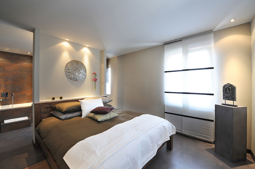 World-inspired bedroom in Montreal with concrete flooring and grey floors.