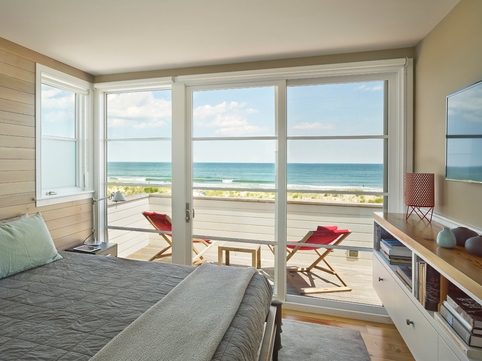 Example of a beach style medium tone wood floor bedroom design in Philadelphia with beige walls