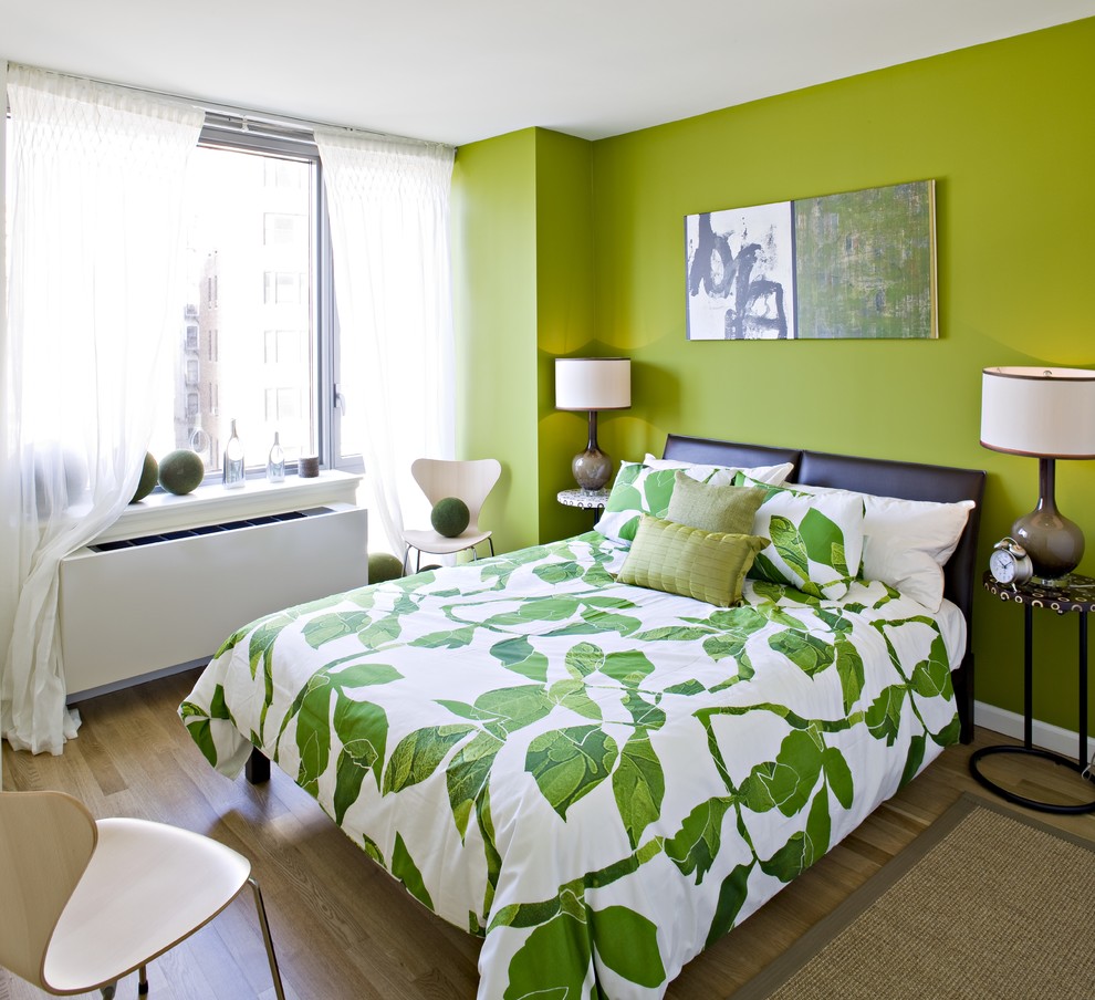 Idée de décoration pour une chambre parentale design de taille moyenne avec un mur vert et parquet clair.