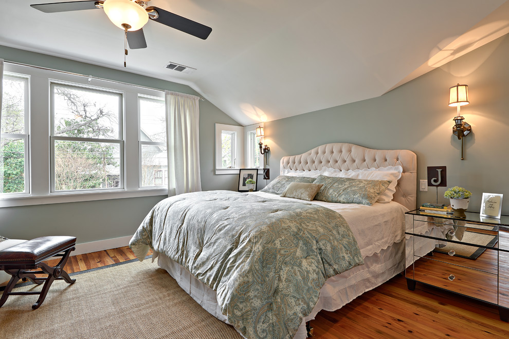 Idée de décoration pour une grande chambre parentale tradition avec un mur bleu, un sol en bois brun et aucune cheminée.