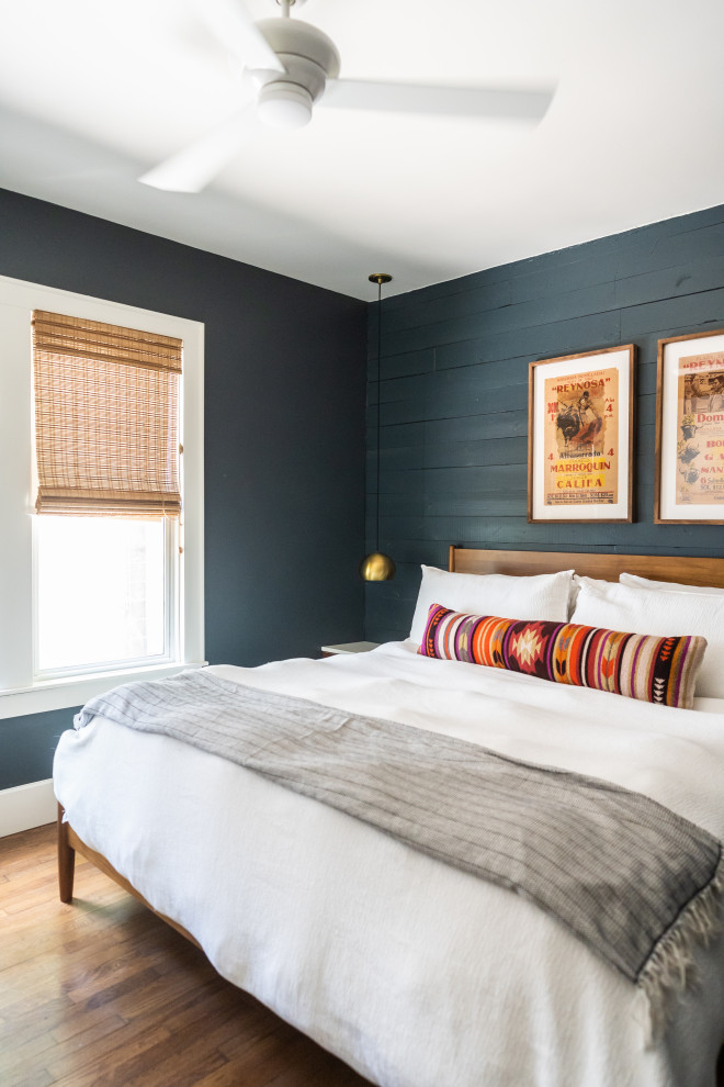 Foto på ett vintage sovrum, med svarta väggar, mellanmörkt trägolv och brunt golv