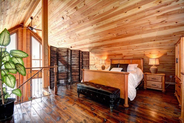 Foto di una piccola camera da letto stile loft stile rurale con pareti marroni e pavimento in legno massello medio