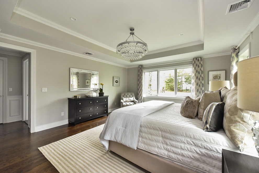 Example of a huge transitional master dark wood floor and brown floor bedroom design in New York with gray walls