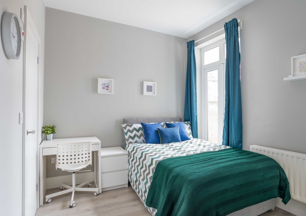 На фото: маленькая гостевая спальня (комната для гостей) в стиле фьюжн с серыми стенами, полом из ламината и серым полом для на участке и в саду с