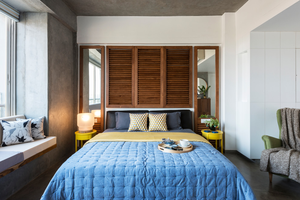 Photo of an urban master bedroom in Ahmedabad with white walls, concrete flooring, no fireplace and grey floors.