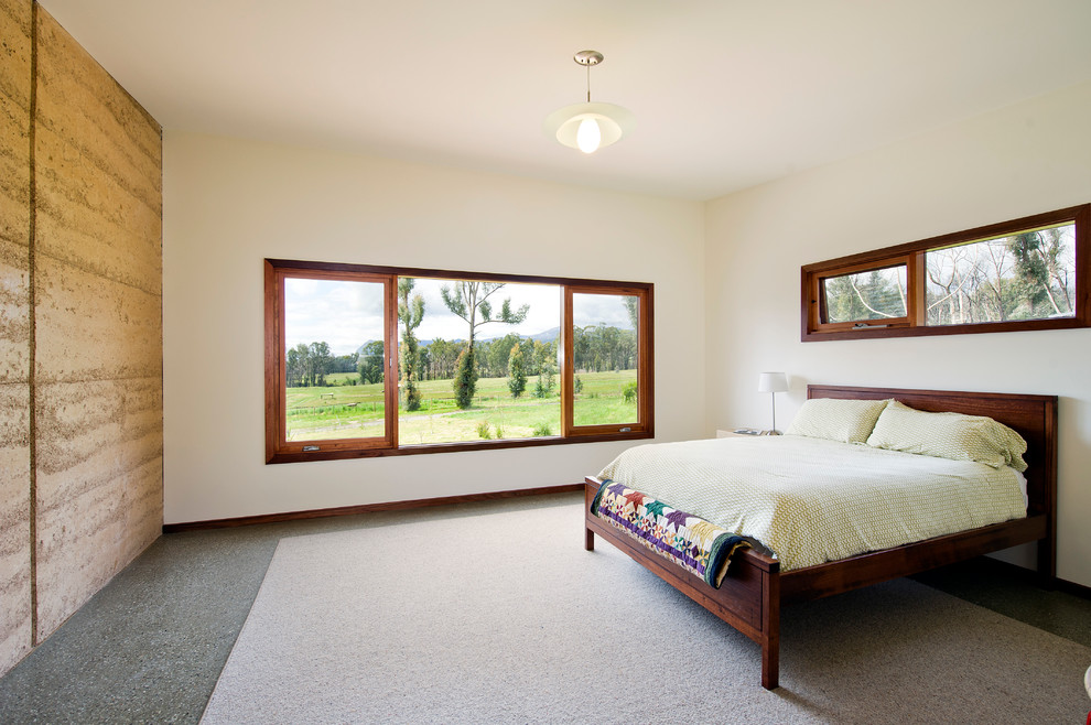 This is an example of a rustic bedroom in Melbourne with concrete flooring.