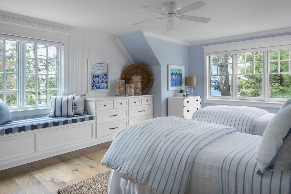 他の地域にあるビーチスタイルのおしゃれな客用寝室 (青い壁、淡色無垢フローリング) のインテリア