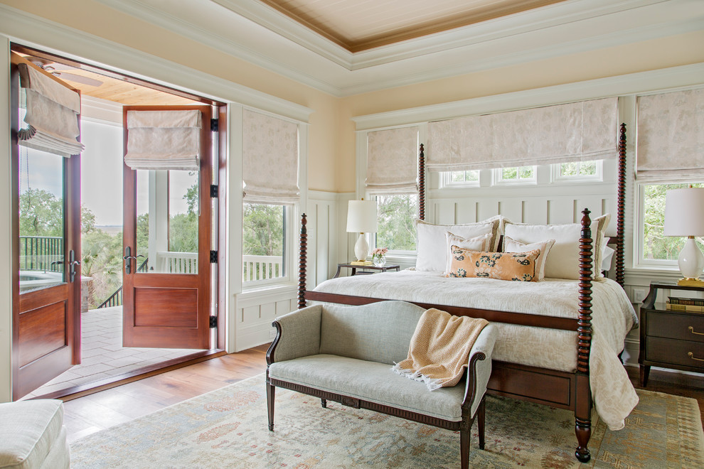 This is an example of a large traditional master bedroom in Charleston with pink walls and medium hardwood flooring.