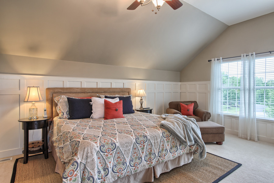 This is an example of a traditional master bedroom in Orange County with beige walls and carpet.