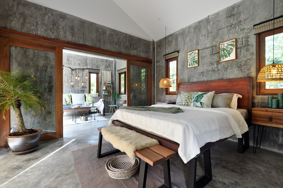 Example of an island style concrete floor and gray floor bedroom design in Singapore with gray walls