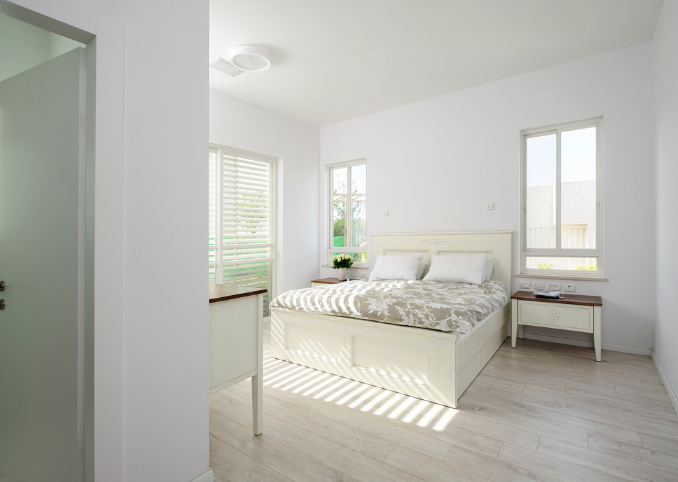 Cette image montre une chambre design avec un mur blanc, parquet clair et aucune cheminée.