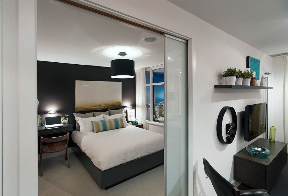 Immagine di una camera da letto contemporanea con pareti bianche, nessun camino e TV