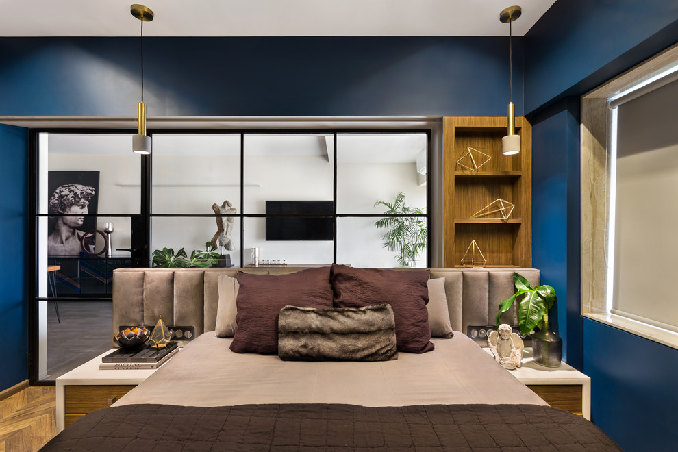 Ispirazione per una camera matrimoniale contemporanea con pareti blu, pavimento in legno massello medio e pavimento marrone