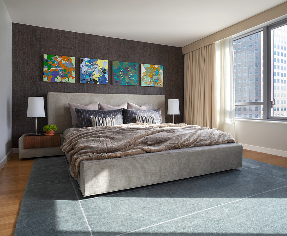 This is an example of a contemporary bedroom in New York with grey walls.