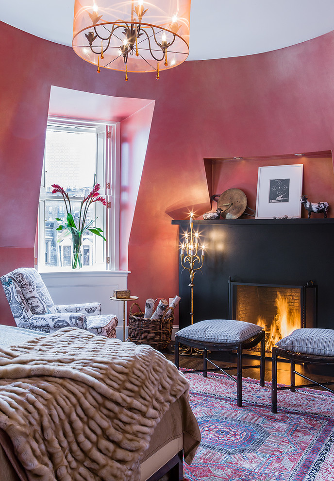 Aménagement d'une grande chambre parentale campagne avec un mur rouge, parquet foncé, une cheminée standard et un manteau de cheminée en métal.