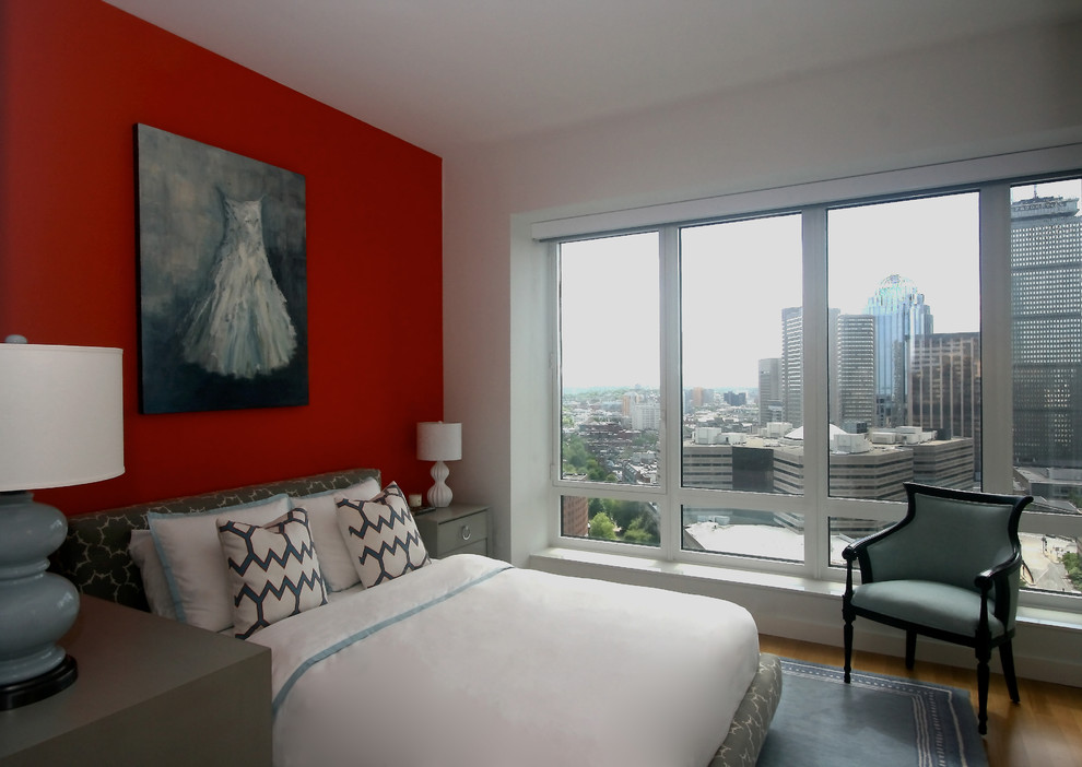Example of a small transitional guest medium tone wood floor bedroom design in Boston with orange walls and no fireplace