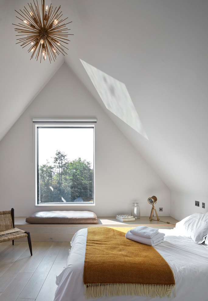 Design ideas for a contemporary guest bedroom in London with white walls, light hardwood flooring and beige floors.