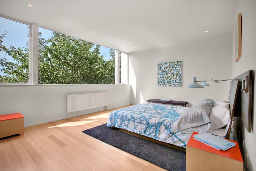 Großes Modernes Hauptschlafzimmer ohne Kamin mit weißer Wandfarbe und hellem Holzboden in Seattle
