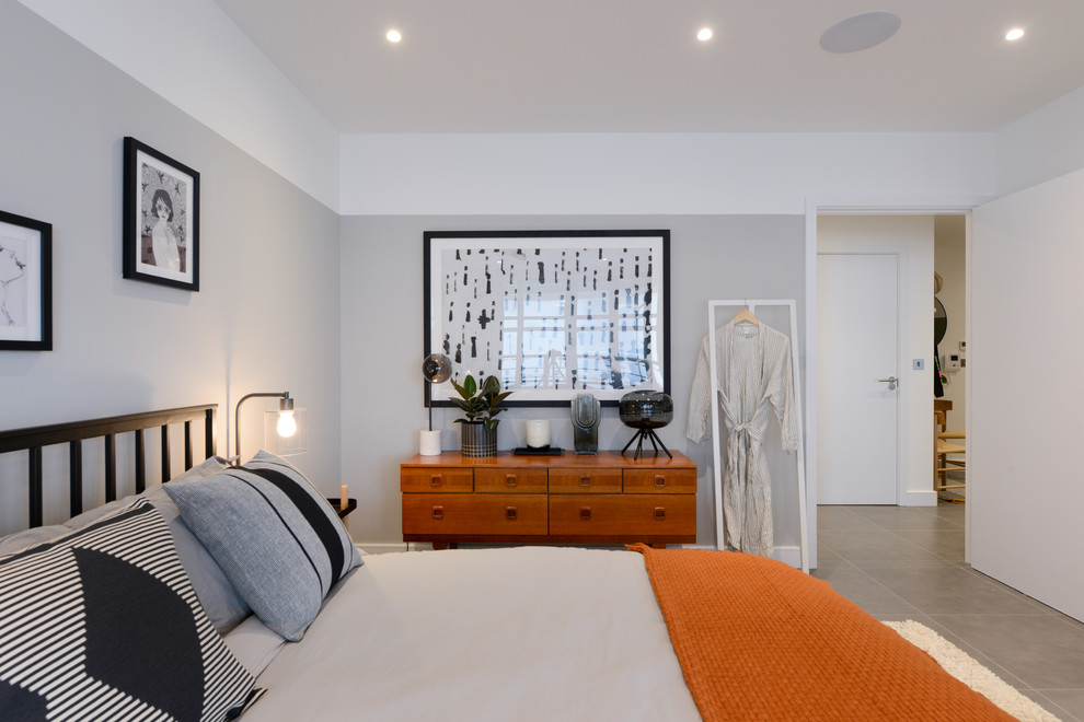 Example of a mid-sized trendy gray floor bedroom design in London with gray walls