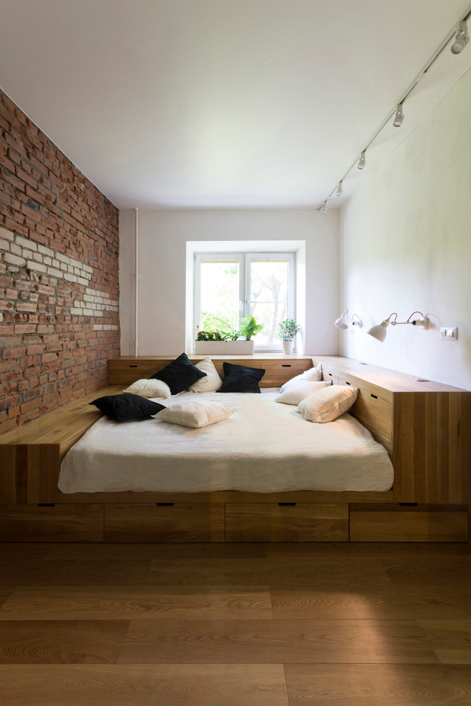 На фото: хозяйская спальня в современном стиле с паркетным полом среднего тона и кроватью в нише с