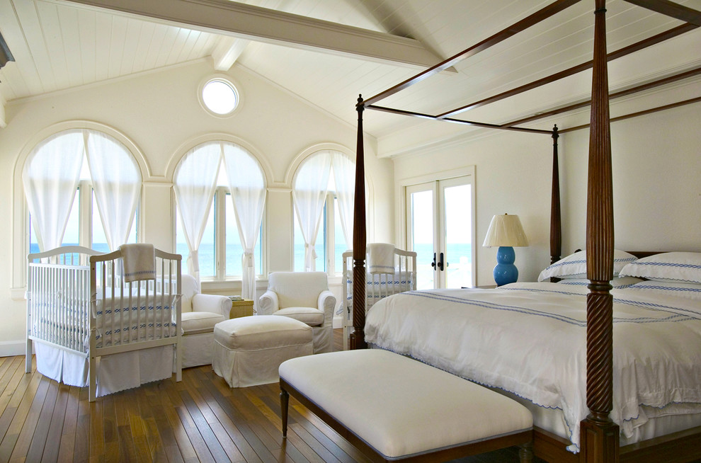 Ispirazione per una camera da letto tropicale con pareti bianche e pavimento in legno massello medio