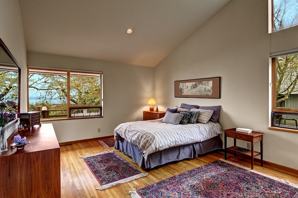 Exemple d'une chambre parentale chic de taille moyenne avec un mur beige, un sol en bois brun et aucune cheminée.