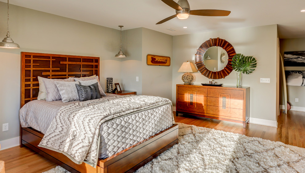 Ejemplo de dormitorio principal costero grande con paredes grises y suelo de madera clara
