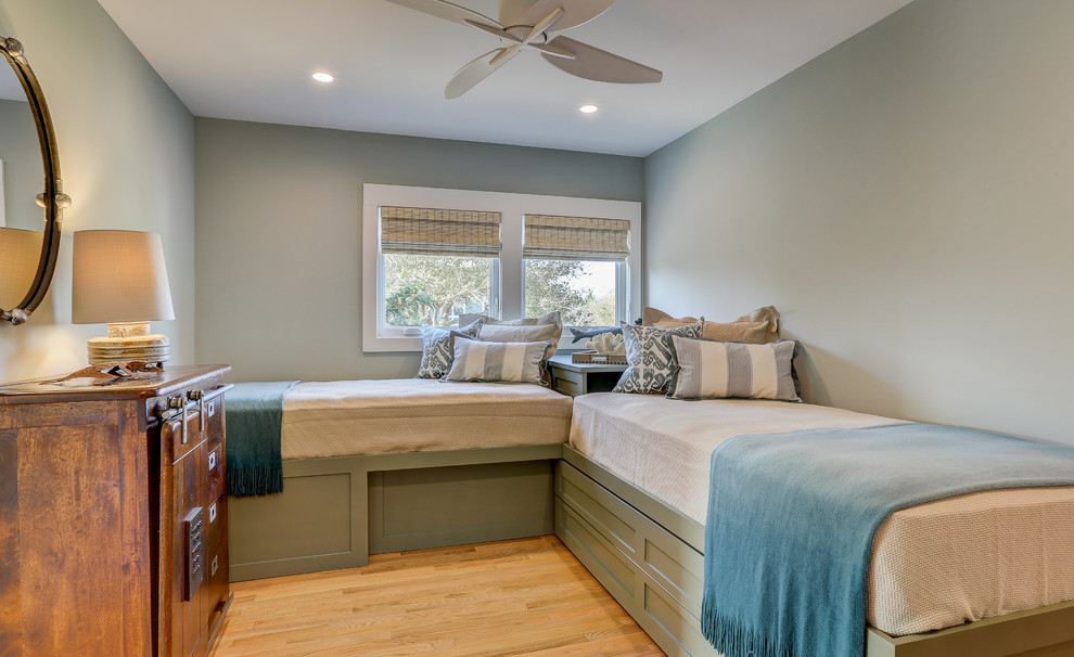This is an example of a medium sized coastal guest bedroom in Other with grey walls and light hardwood flooring.