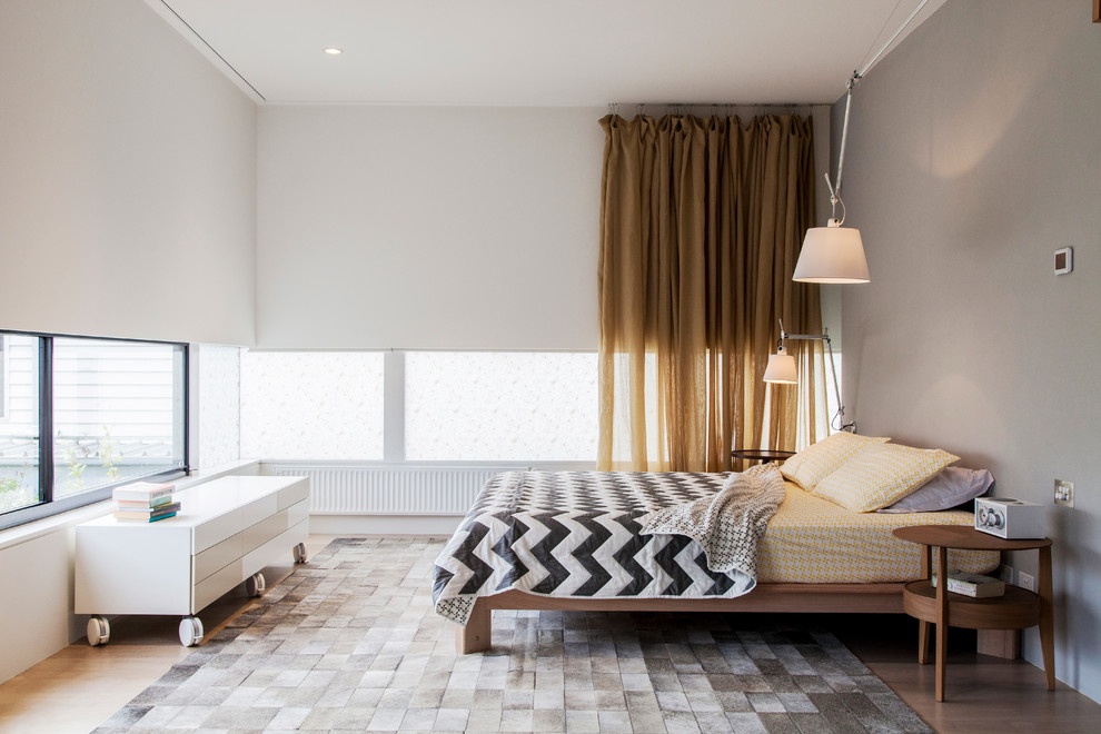 メルボルンにあるコンテンポラリースタイルのおしゃれな主寝室 (グレーの壁、淡色無垢フローリング)