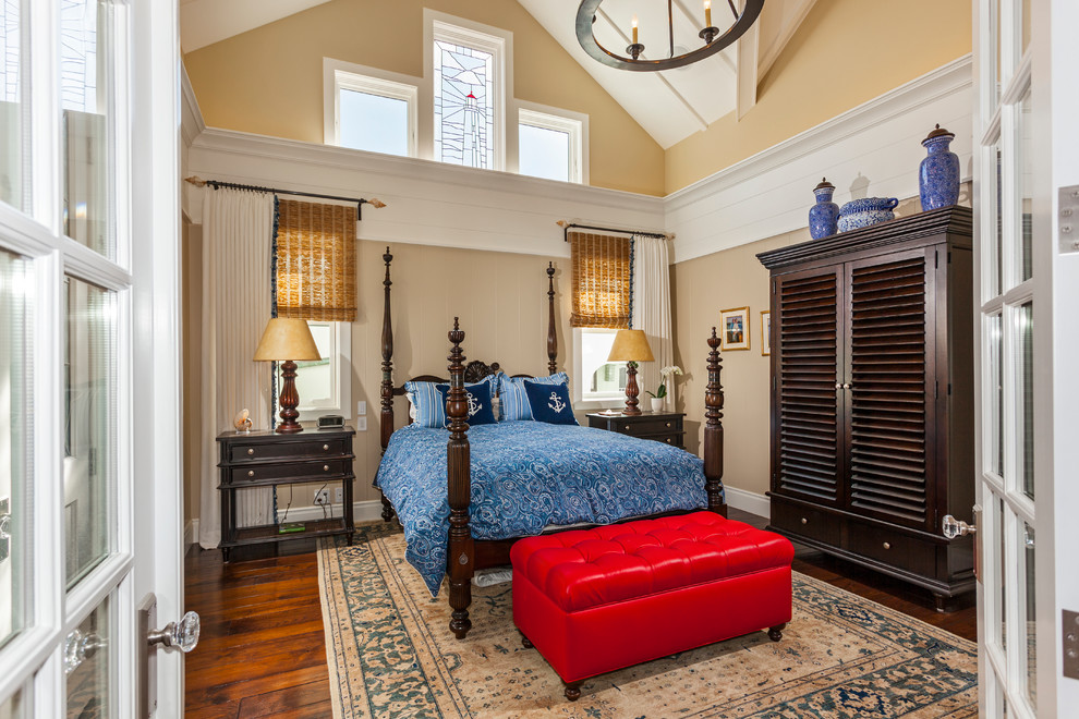 This is an example of a coastal bedroom in Orange County with beige walls and dark hardwood flooring.