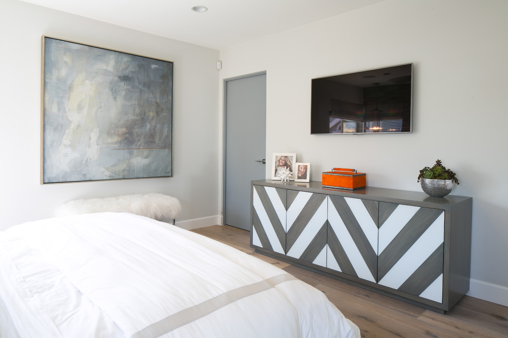 Ejemplo de dormitorio principal actual de tamaño medio con paredes grises y suelo de madera clara