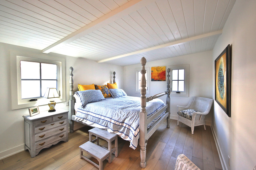 Ispirazione per una camera degli ospiti country di medie dimensioni con pareti bianche, parquet chiaro e pavimento marrone