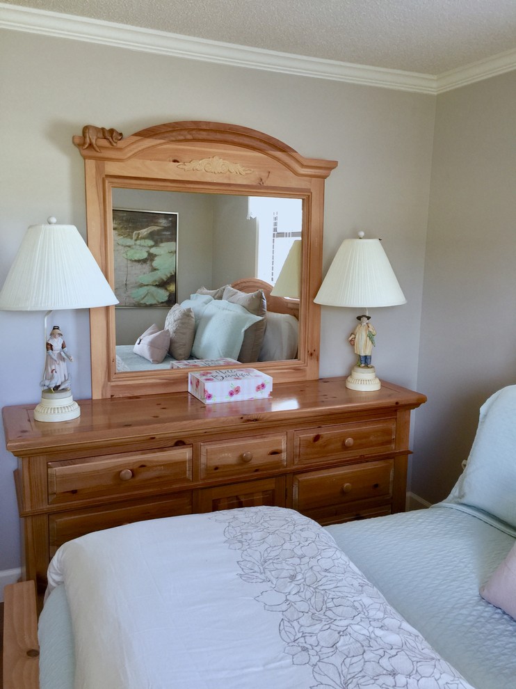 Modelo de habitación de invitados clásica de tamaño medio con paredes grises, suelo de madera en tonos medios y suelo marrón