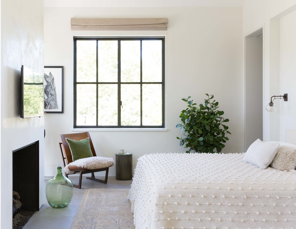 Foto de dormitorio campestre con paredes blancas, todas las chimeneas y suelo gris
