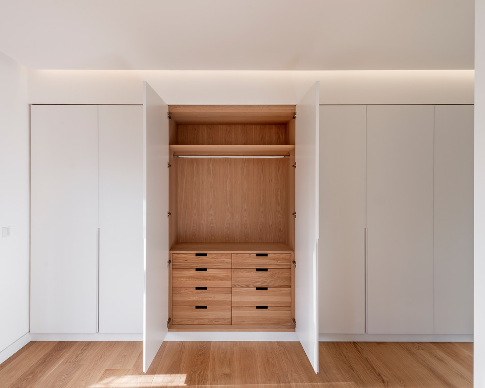 Imagen de dormitorio principal escandinavo de tamaño medio con paredes blancas y suelo de madera en tonos medios