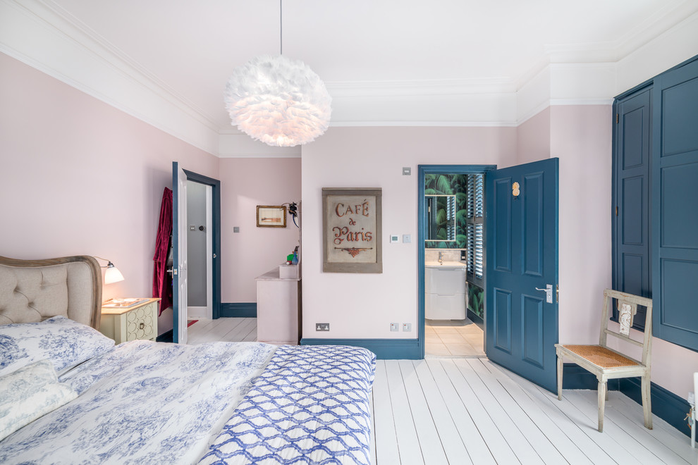 Vintage guest bedroom in London with pink walls, painted wood flooring and white floors.