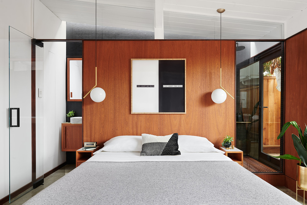 Cette image montre une petite chambre parentale design avec un mur marron, sol en béton ciré et un sol gris.