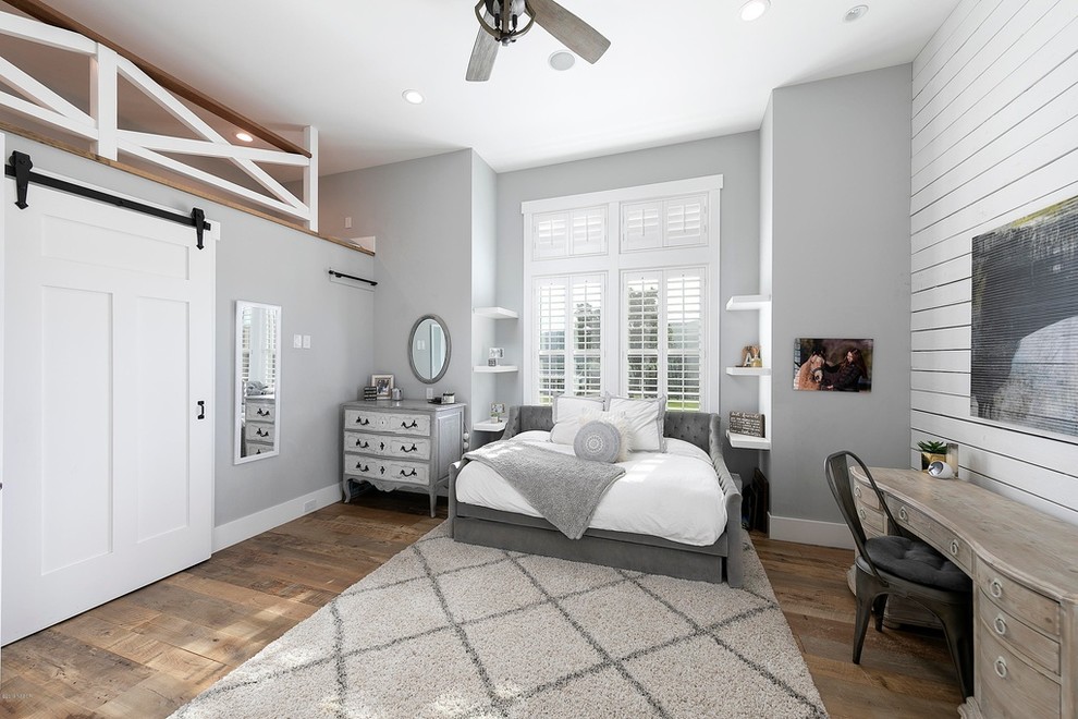 Design ideas for a medium sized country guest and grey and brown loft bedroom in Orange County with grey walls, medium hardwood flooring, no fireplace and brown floors.