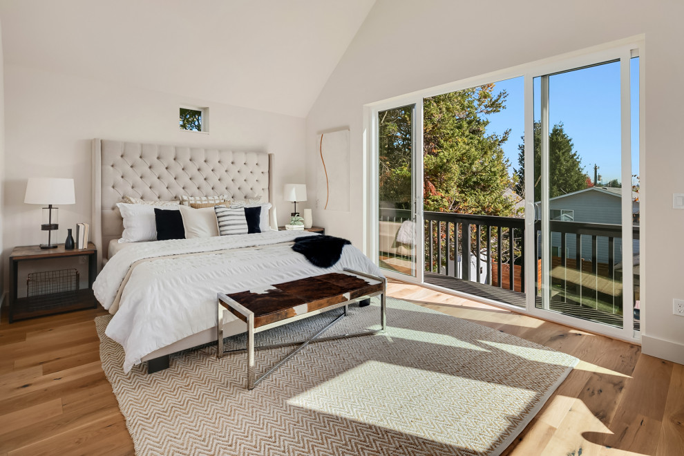 Ejemplo de dormitorio principal de estilo de casa de campo de tamaño medio con paredes blancas, suelo de madera en tonos medios y suelo marrón