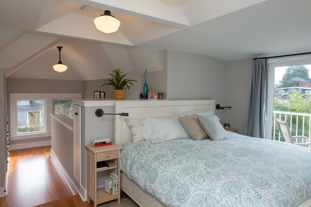 Ejemplo de dormitorio tipo loft de estilo americano de tamaño medio sin chimenea con paredes grises y suelo de madera en tonos medios
