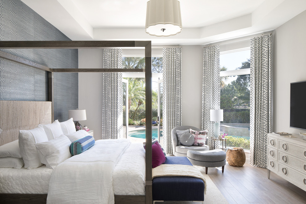Coastal grey and brown bedroom in Miami with grey walls, medium hardwood flooring and brown floors.