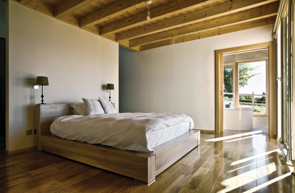 На фото: большая хозяйская спальня в современном стиле с белыми стенами и светлым паркетным полом