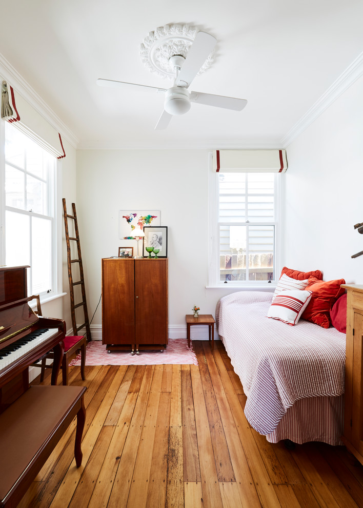 シドニーにある小さなトラディショナルスタイルのおしゃれな客用寝室 (白い壁、無垢フローリング、茶色い床) のレイアウト