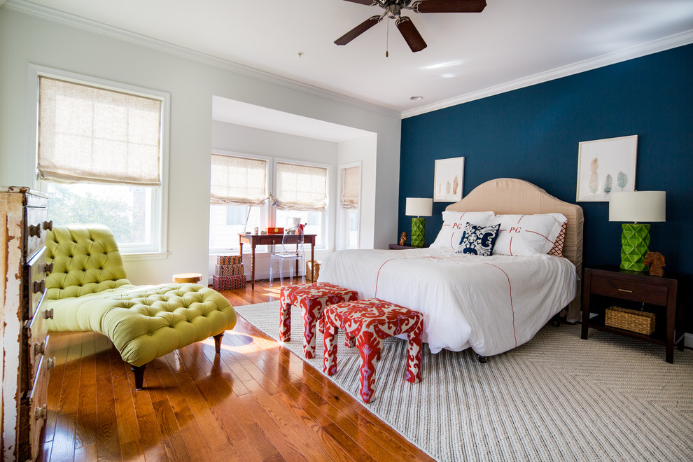 Modelo de dormitorio principal clásico renovado de tamaño medio con paredes azules y suelo de madera en tonos medios