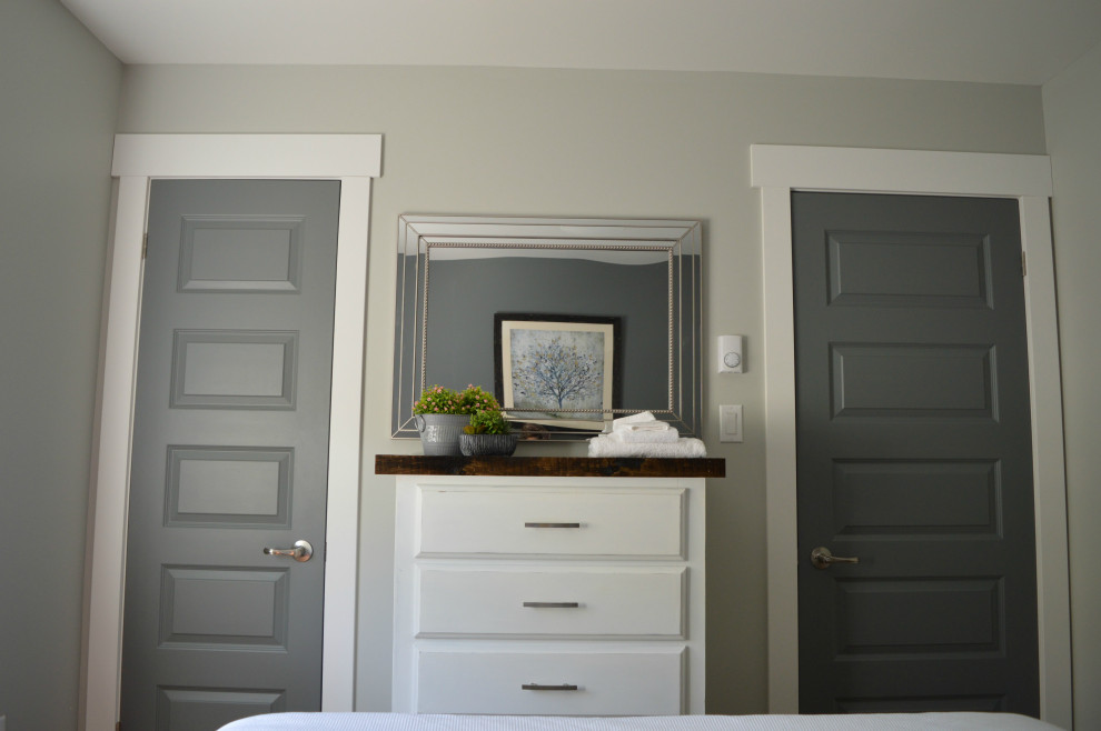 Diseño de habitación de invitados costera con paredes grises, suelo de madera clara y suelo beige